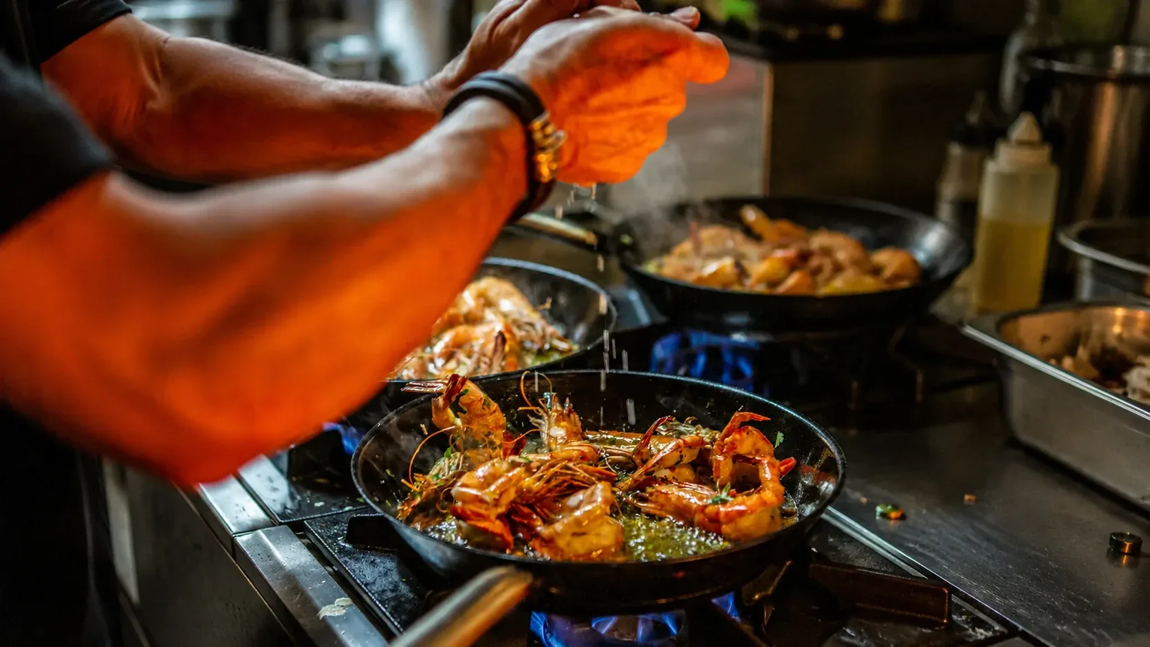 Chef finishing garlic shrimp over an open flame at Mexico De Noche