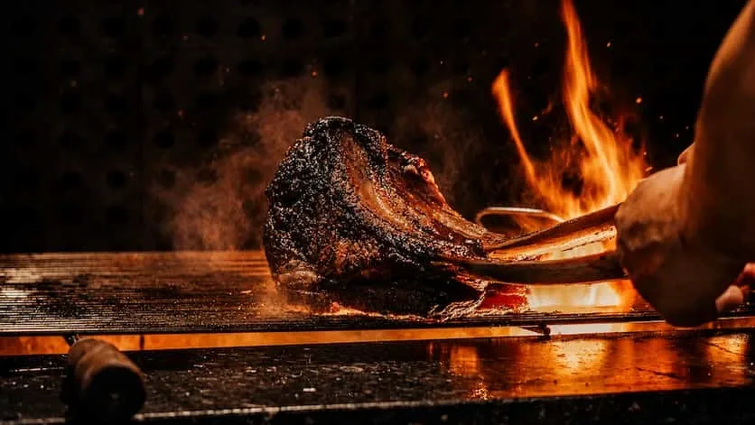 Bone-in ribeye searing over an open flame at Mexico De Noche